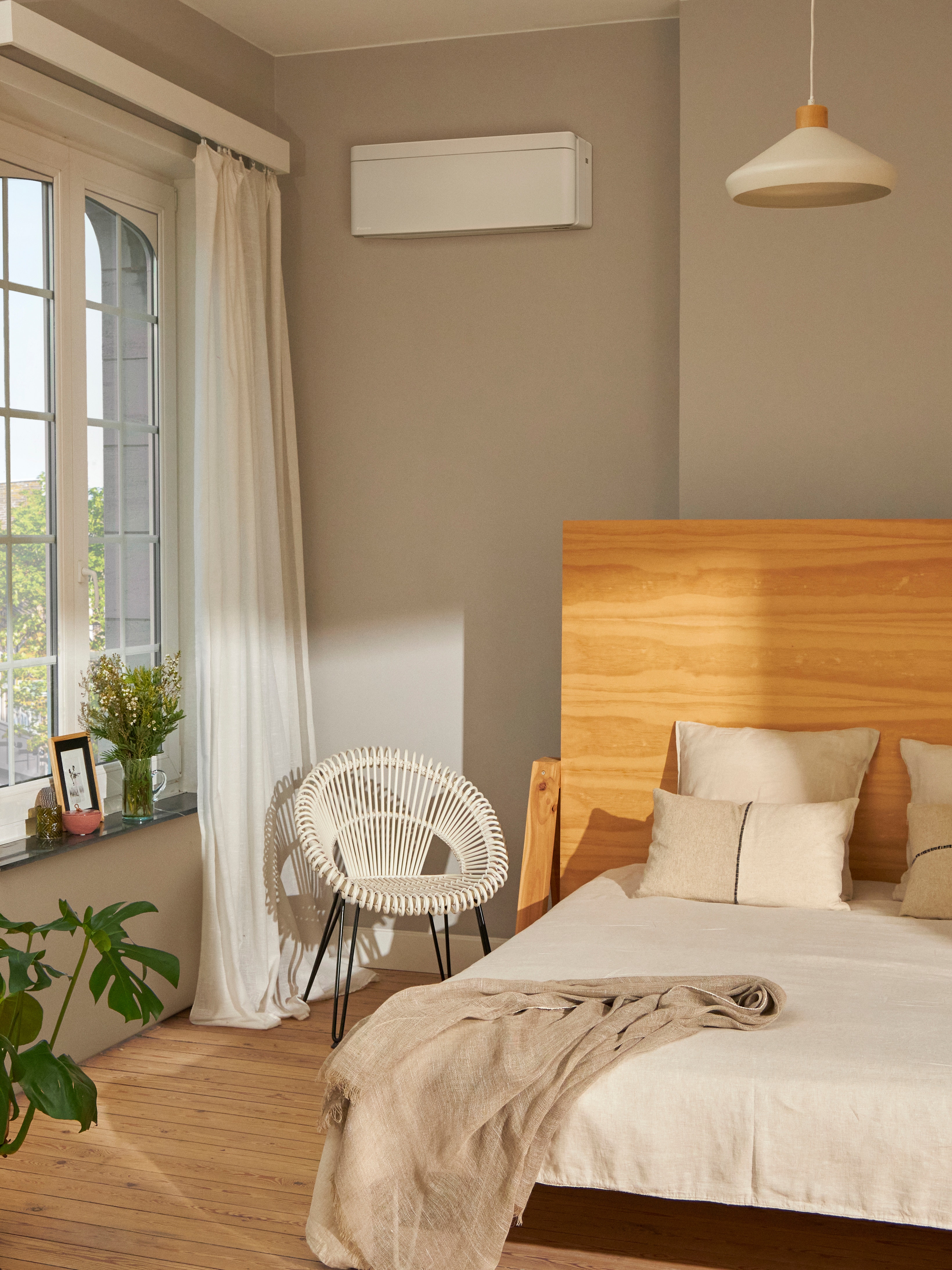 Et smukt soveværelse med et hvidt, vægmonteret klimasystem.