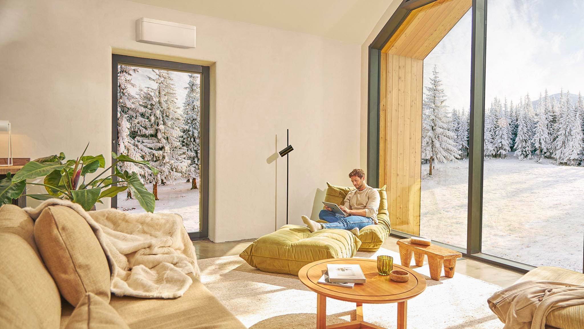 En mand sidder i en sofa og nyder varmen fra et klimaanlæg.