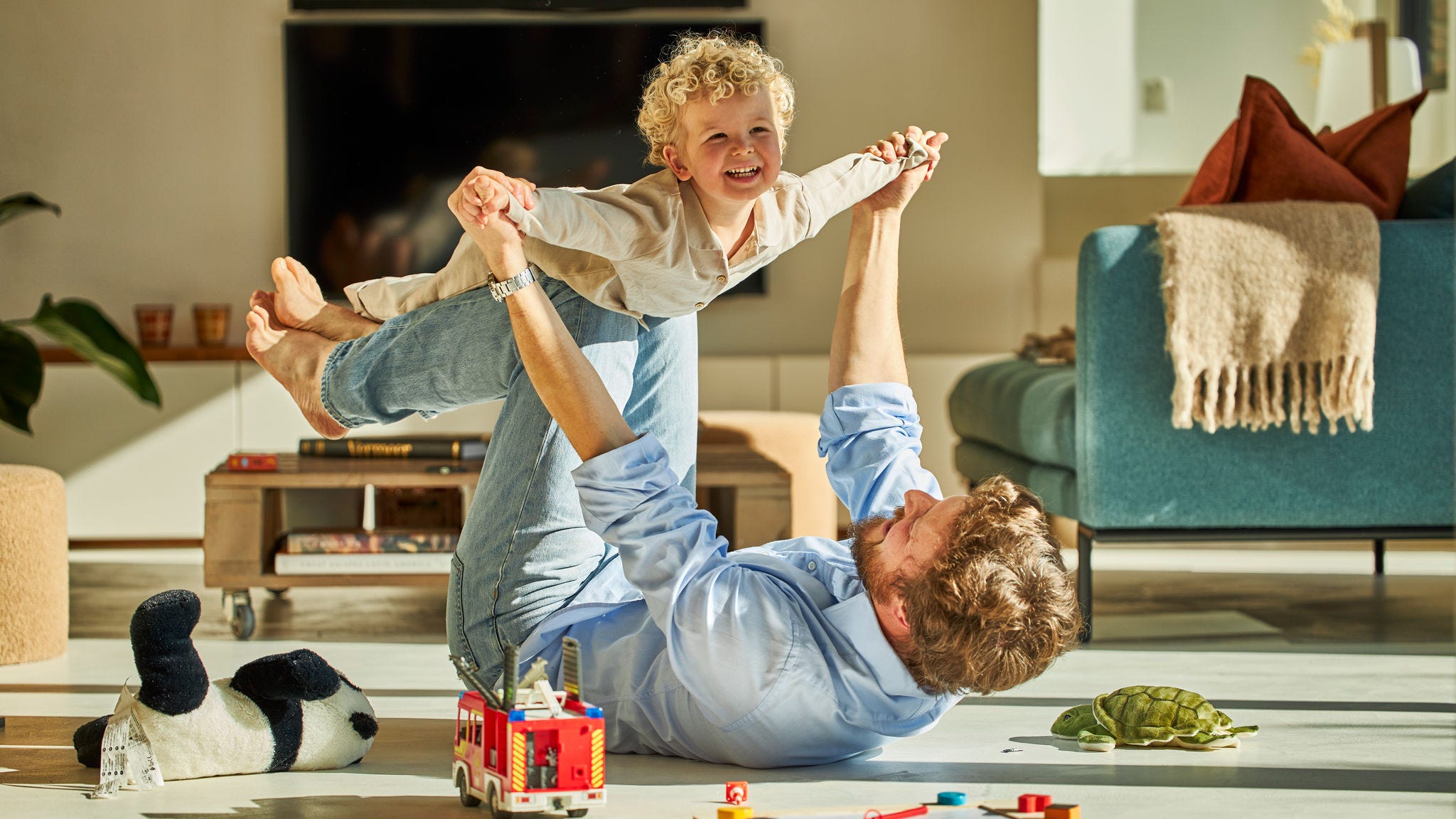 Far og barn, der leger og har det sjovt sammen, mens de nyder den kølige luft.