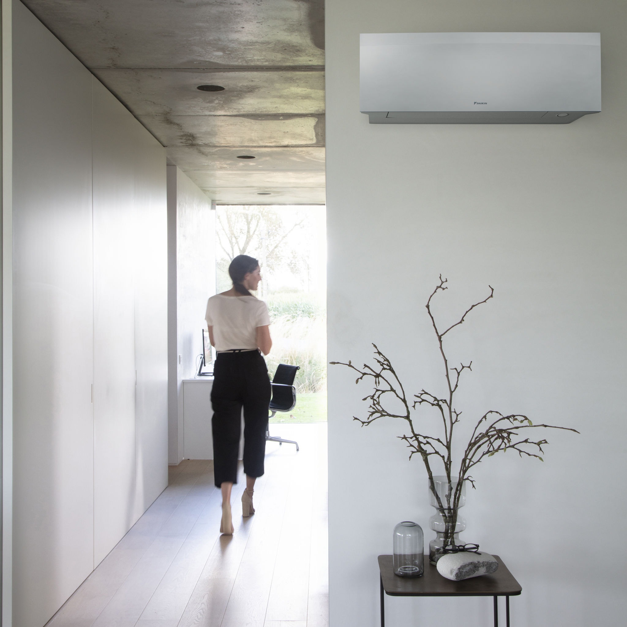 Lady walking down passage Daikin unit on wall