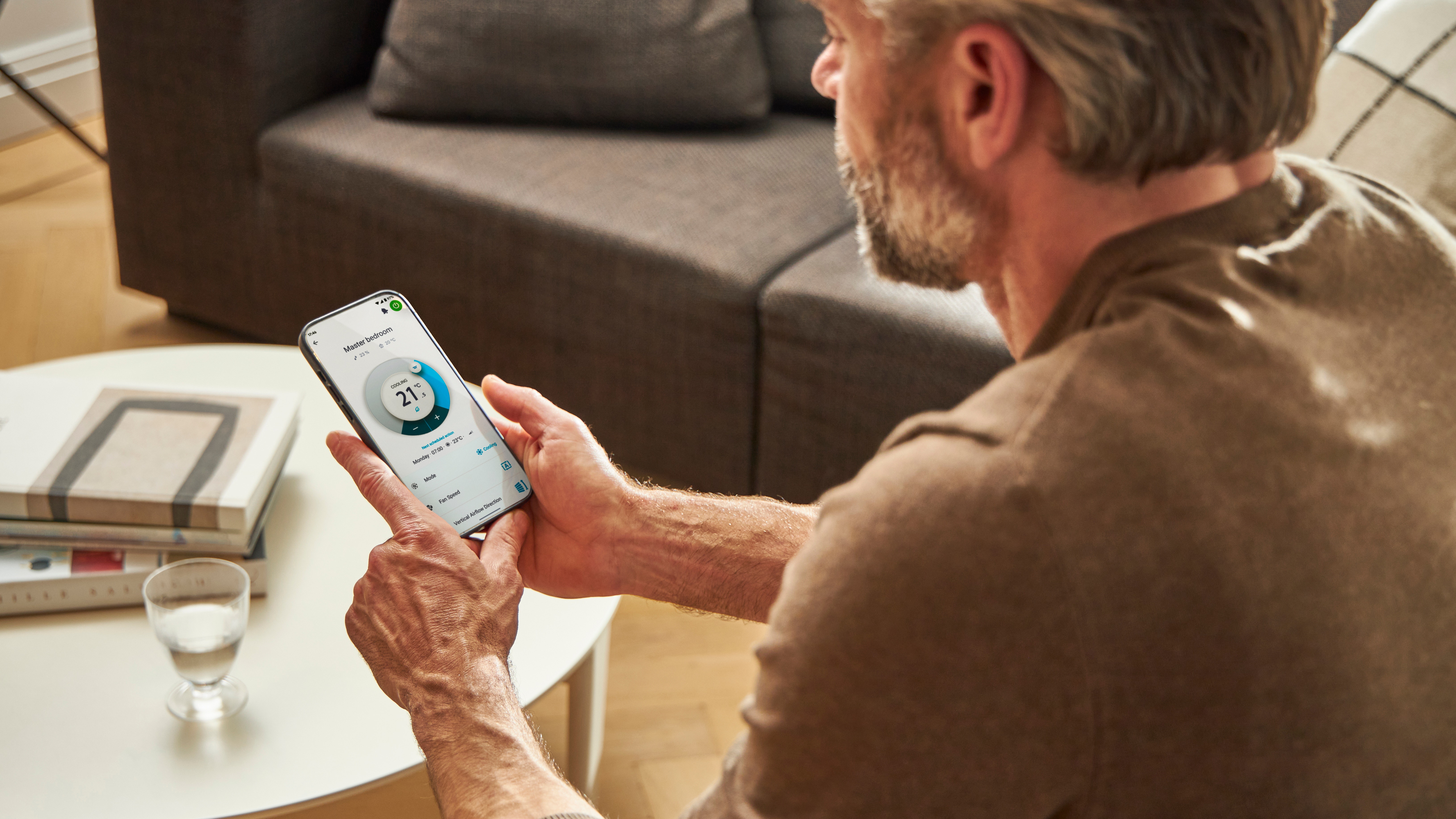 En mand bruger en app til at betjene sin opvarmningsløsning.