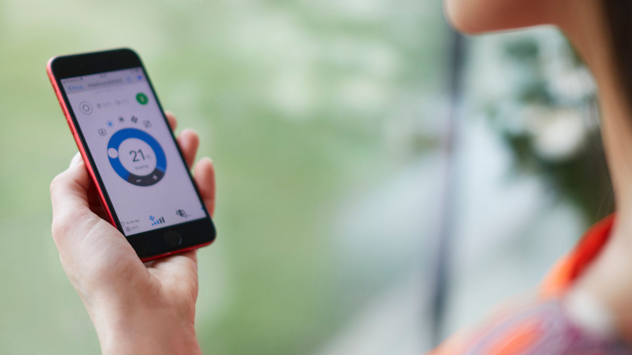 En kvinde, der bruger en app til at betjene sin opvarmningsløsning.