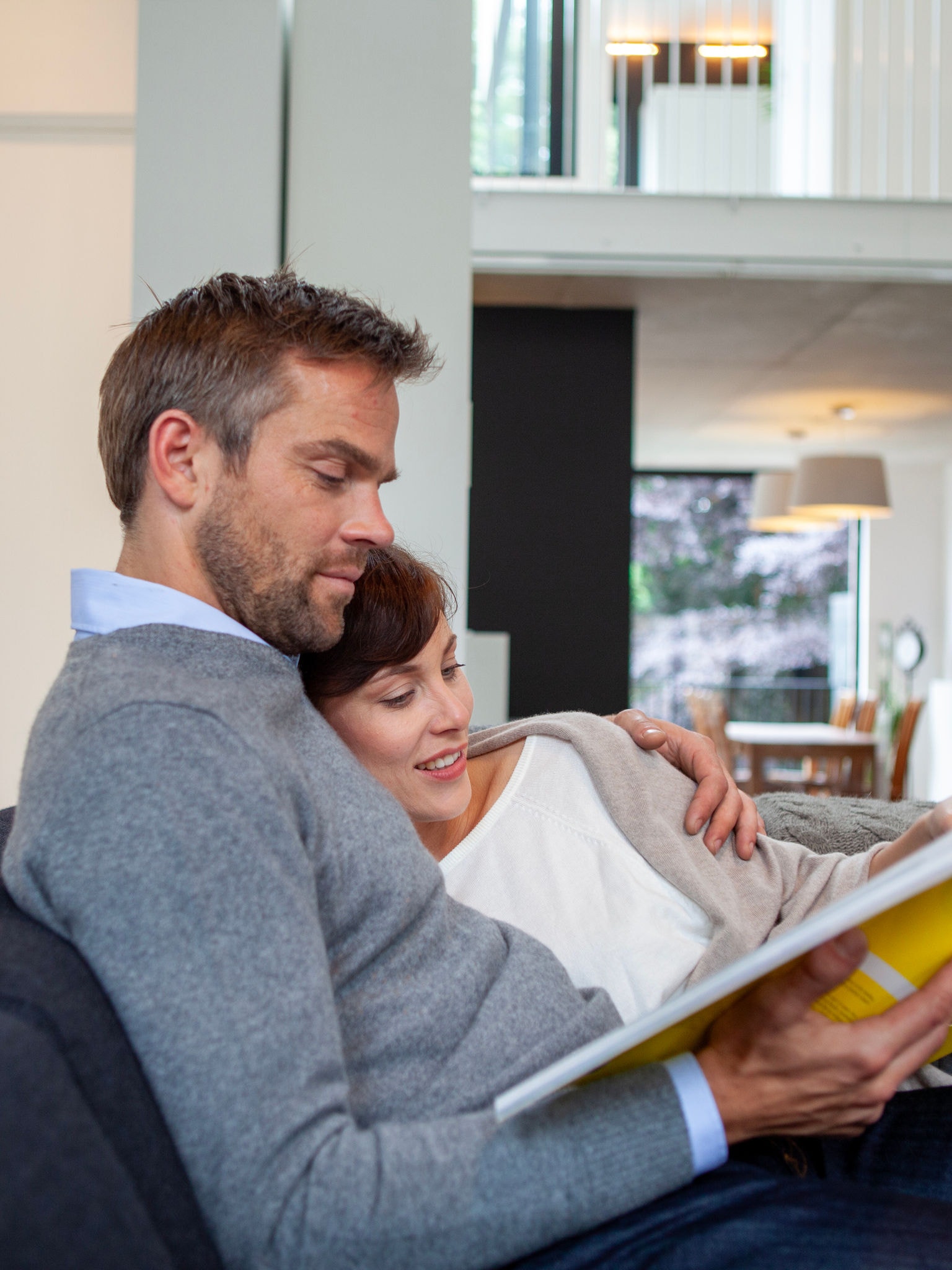 Et par putter i en sofa og kigger i en bog.