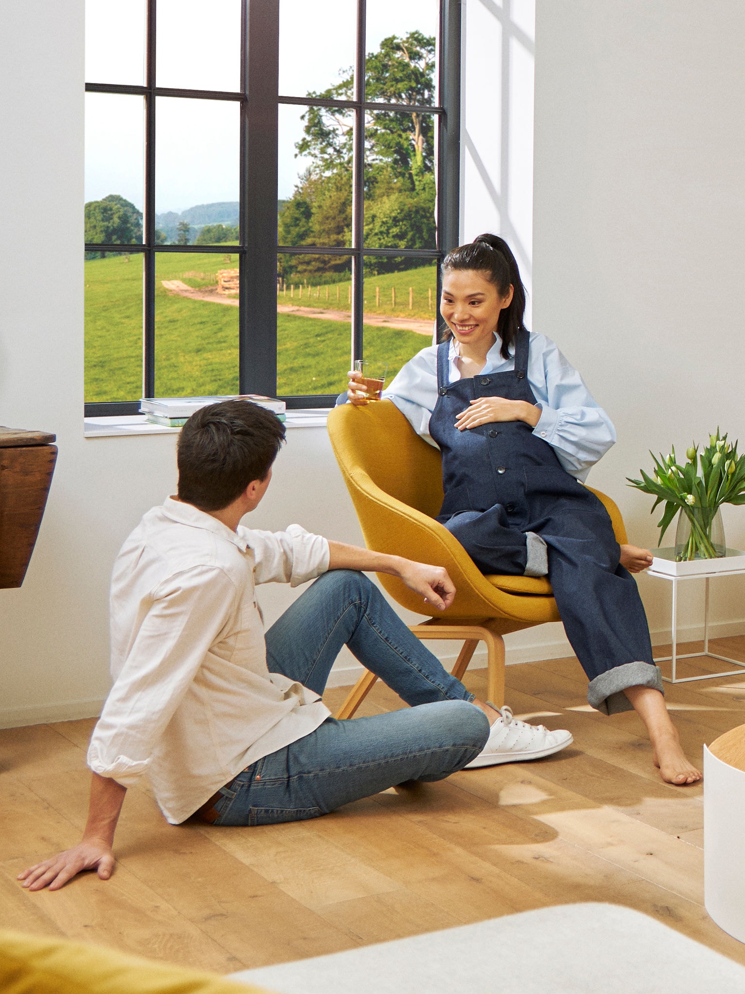 Vordende forældre slapper af i deres stue i en behagelig temperatur, som leveres af en Daikin-varmepumpe.