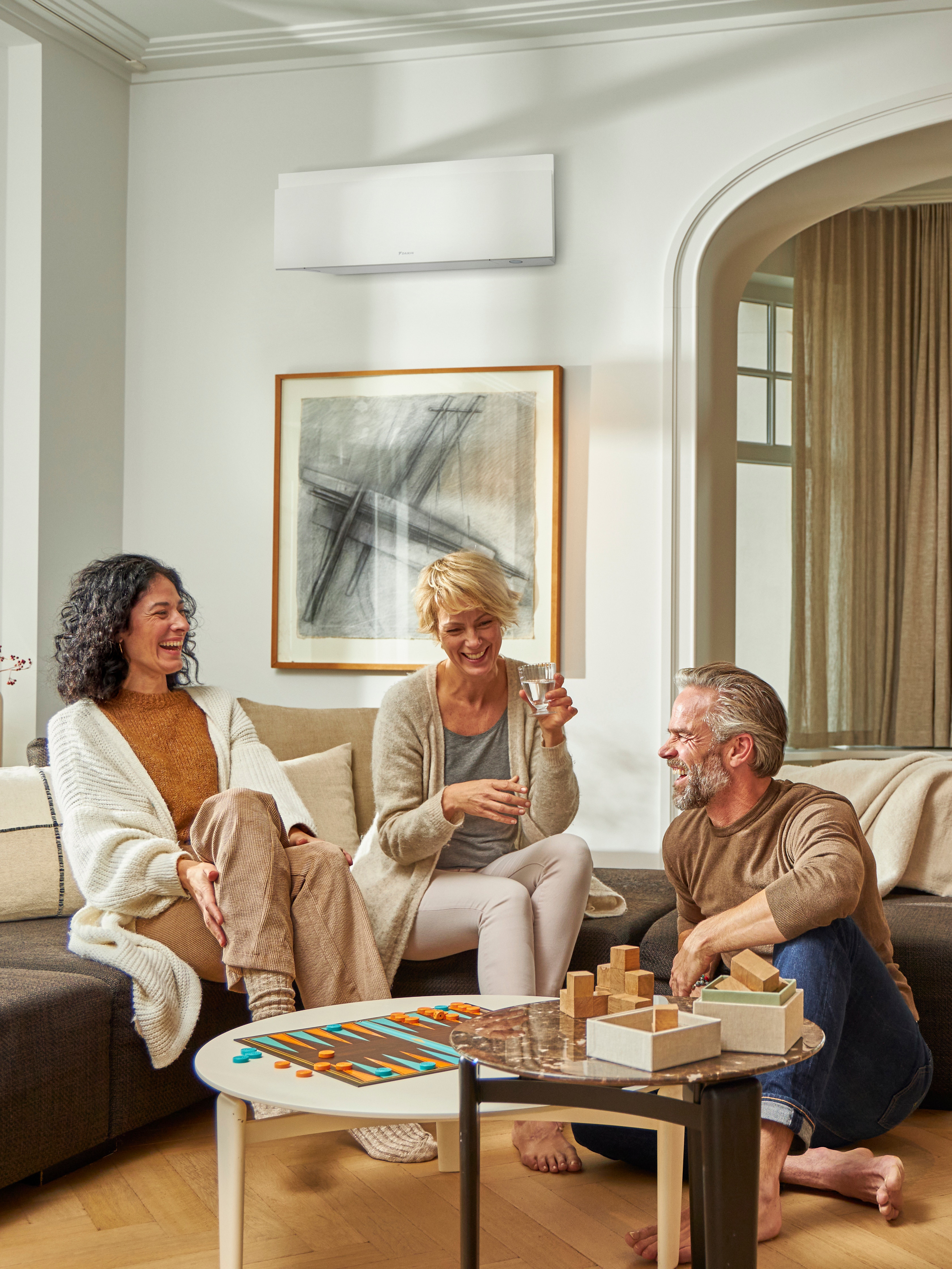 Tre venner spiller et brætspil i en perfekt temperatur.