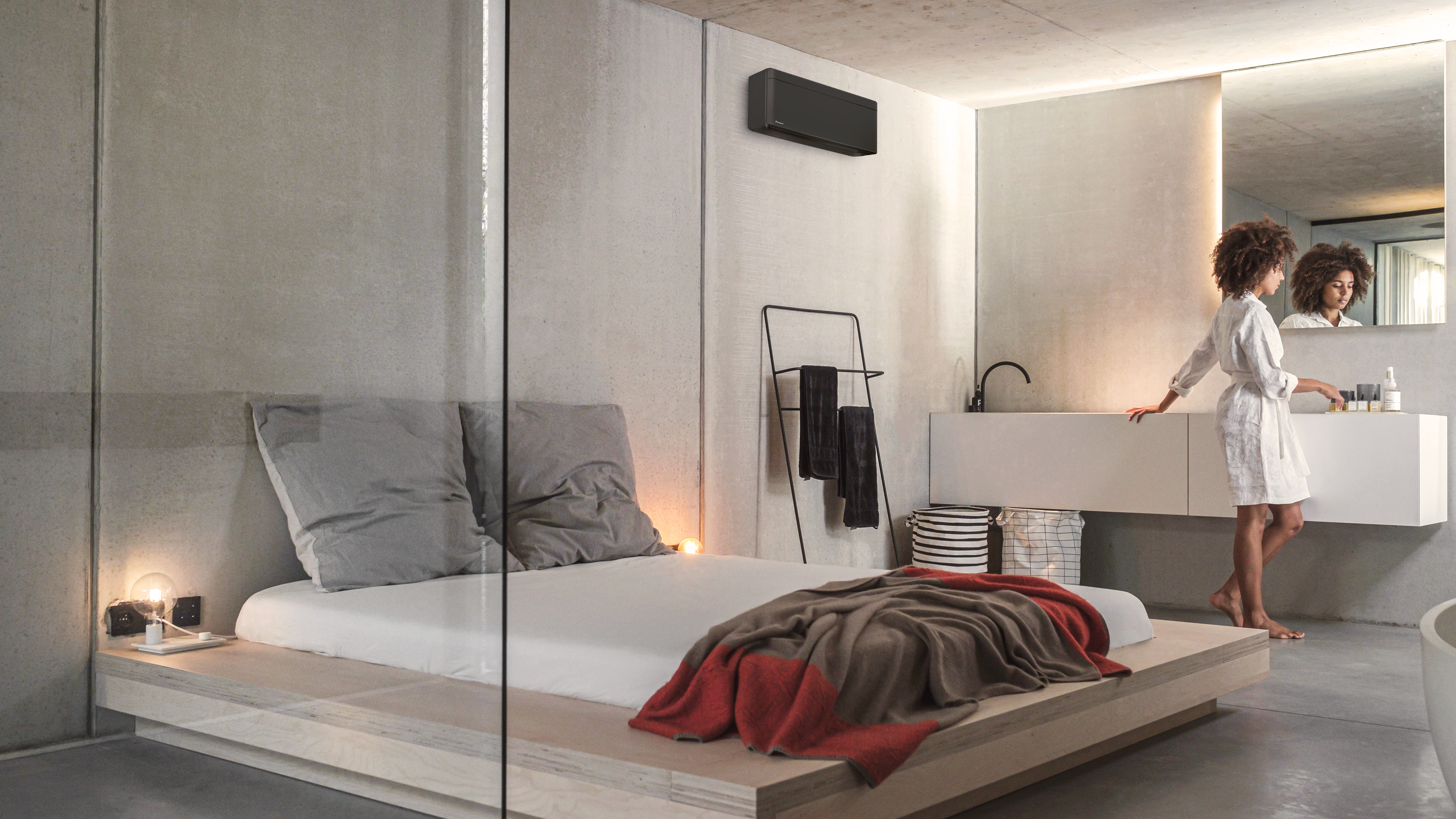 En kvinde i sit soveværelse, hvor der er et flot Daikin-klimaanlæg.